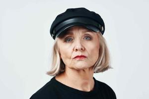 idosos mulher dentro uma Preto chapéu moda fechar-se luz fundo foto