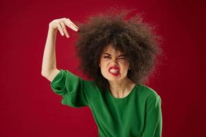 lindo elegante menina afro Penteado verde vestir emoções fechar-se vermelho fundo inalterado foto