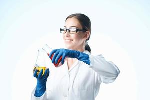 alegre mulher dentro uma branco casaco análise química experimentos foto