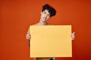 cara com encaracolado cabelo ilha dentro mãos publicidade vermelho fundo foto