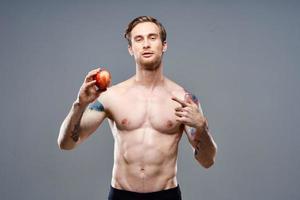 homem com maçã e esporte saudável Comida bombeado acima bolo fisiculturista foto