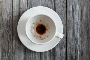 esvaziar copo com café sobras em de madeira mesa, fechar-se foto