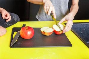 mãe e crianças cozinhando dentro cozinha e tendo Diversão foto