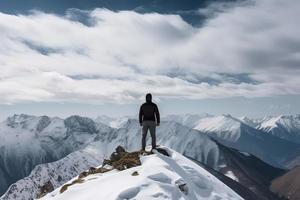 homem em pé em a topo do uma coberto de neve montanha pico. panorâmico Visão foto