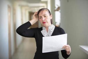 mulher às trabalhos com papéis. a empregado resolve a problema. foto