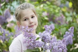 bielorrússia, a cidade do gomel, pode 11, 2019. aberto dia dentro jardim de infância.a criança dentro uma lilás. fofa pequeno pré escola menina com uma ramalhete do Primavera flores foto