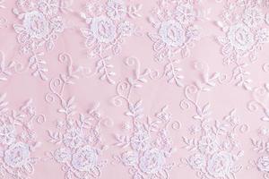 elegante fundo com uma renda branco padronizar em Rosa cetim. delicado fundo textura. foto