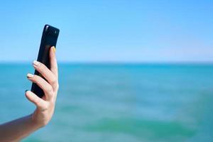 smartphone na mão de uma mulher no fundo do mar