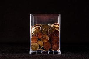 transparente vidro com moedas foto