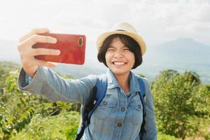 jovem mulher viajante levando selfie com montanha Visão foto