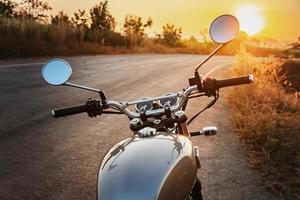 clássico estilo motocicleta em estrada com pôr do sol foto