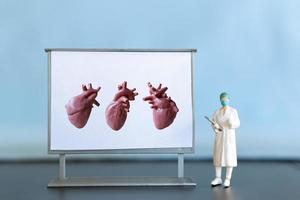 miniatura pessoas. médico é diagnóstico coração doença em tela foto