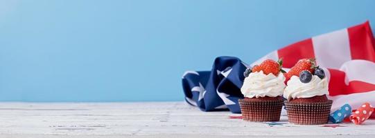 doce bolos de copo com amoras e morango , EUA bandeira em azul fundo foto