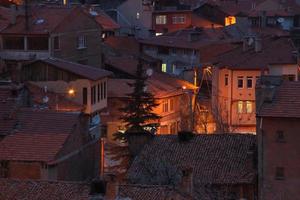 casas com uma luz em dentro a meio do a noite foto