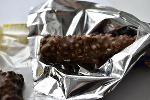 deliciosa barra de chocolate com nozes em um pacote foto