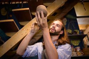 cerâmica artista, jovem fazer uma peça do argila moldagem calmamente e meticulosamente dentro ordem para produzir a a maioria atraente trabalhos possível, foto