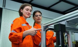 ambos do mulher dentro a eletrônico partes fábrica usando uma Produção linha controlador e estão recomendando colegas para usar isto ferramenta. foto