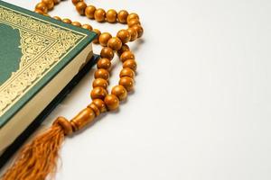 a piedosos al Alcorão com escrito árabe caligrafia significado do al Alcorão e rosário miçangas ou tasbih em branco fundo, isolado com cópia de espaço. foto