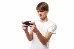 uma homem dentro uma branco camiseta com uma controle de video game dentro dele mãos jogando passatempo estilo de vida foto