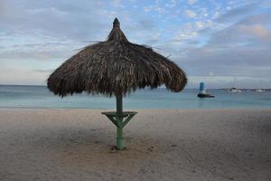 Relva de praia cabana em uma areia de praia dentro Aruba foto