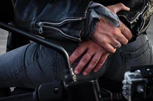 mãos de um motociclista abraçando outro motociclista em uma motocicleta