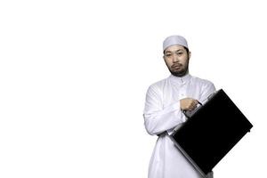 retrato do inteligente bonito muçulmano homem em branco plano de fundo, ramadã festival conceito, islâmico masculino segurando uma o negócio do homem saco em uma branco fundo foto