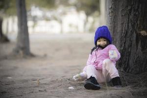 retrato do fofa ásia pequeno menina vestem inverno roupas às a floresta do a parque, tailândia pessoas pose para levar uma foto, feliz Tempo foto