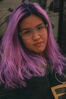 retrato do óculos ásia fêmea com roxa cabelo cor foto