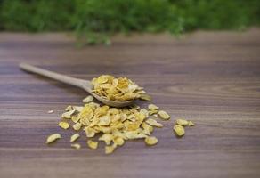 flocos de milho na mesa de madeira foto