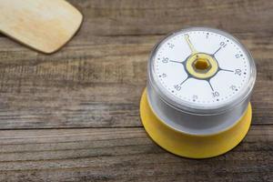 Panificação e utensílios de cozinha com cronômetro de cozinha em uma mesa de madeira foto