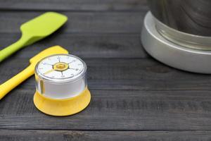 cronômetro de cozinha e utensílios de cozinha em uma mesa de madeira foto