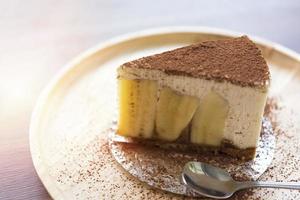 torta de banoffee com chocolate em pó em um prato de madeira foto