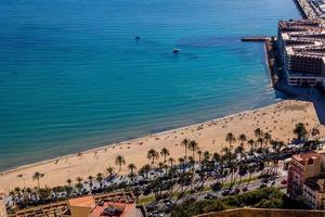 panorama a partir de acima em a praias do playa del postiguet em uma ensolarado dia areia água pessoas lazer foto