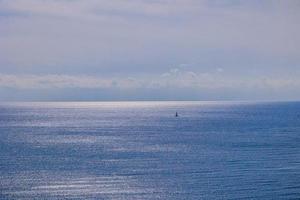 alm azul beira-mar panorama com água e céu e veleiros foto