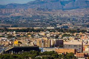 Visão em uma ensolarado dia do a cidade e colorida edifícios a partir de a ponto de vista alicante Espanha foto