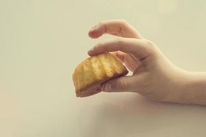 saboroso pequeno Páscoa Bolinho em uma criança mão em uma luz fundo foto