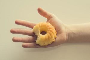 saboroso pequeno Páscoa Bolinho em uma criança mão em uma luz fundo foto