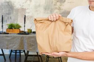 jovem homem entregando Comida para cliente às porta foto