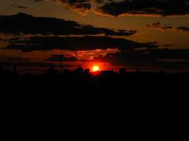 outono pôr do sol vermelho com um céu roxo foto