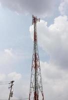 torre de telecomunicações em um fundo de céu nublado foto