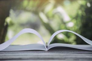 caderno branco e lápis sobre uma superfície de madeira com um fundo desfocado foto