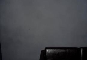 Preto couro sofá dentro cinzento quarto cortada Visão cópia de espaço foto
