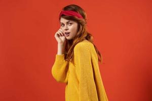 mulher dentro amarelo suéter com vermelho arco de cabelo moda foto