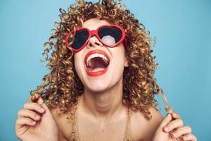 alegre mulher inclinar seu cabeça costas brilhante tarde Maquiagem vermelho lábios azul foto