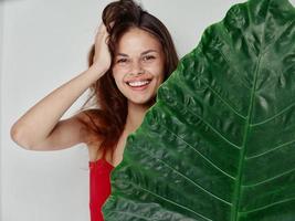 emocional mulher com verde Palma folha vermelho camiseta luz fundo modelo foto