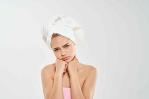 mulher com toalha em cabeça segurando face pele Cuidado dermatologia saúde foto