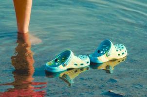 sapatos de borracha azul na água foto