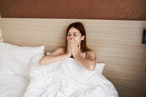 mulher mentiras dentro cama dentro descansar quarto manhã foto