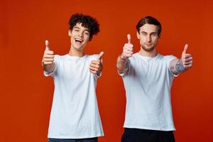 dois alegre amigos estão gesticulando com seus mãos emoções Diversão estúdio foto