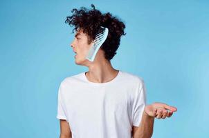 fofa cara com uma pente cabelo cachos branco camiseta azul fundo foto